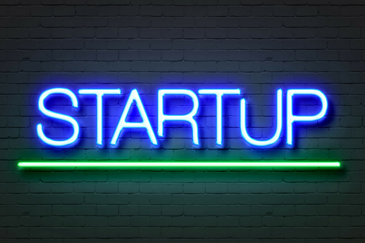 A neon sign that says "STARTUP"