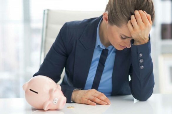 Woman in suit with head in her hand looking hopeless.