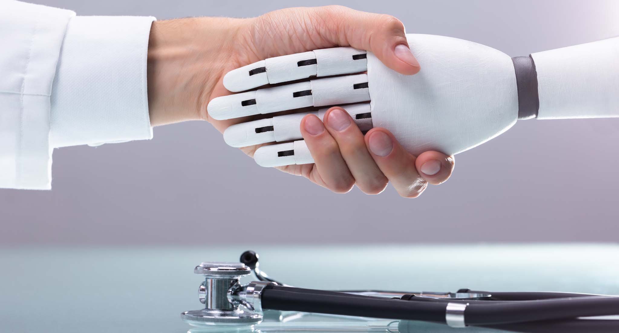 A human hand shaking a robotic hand.