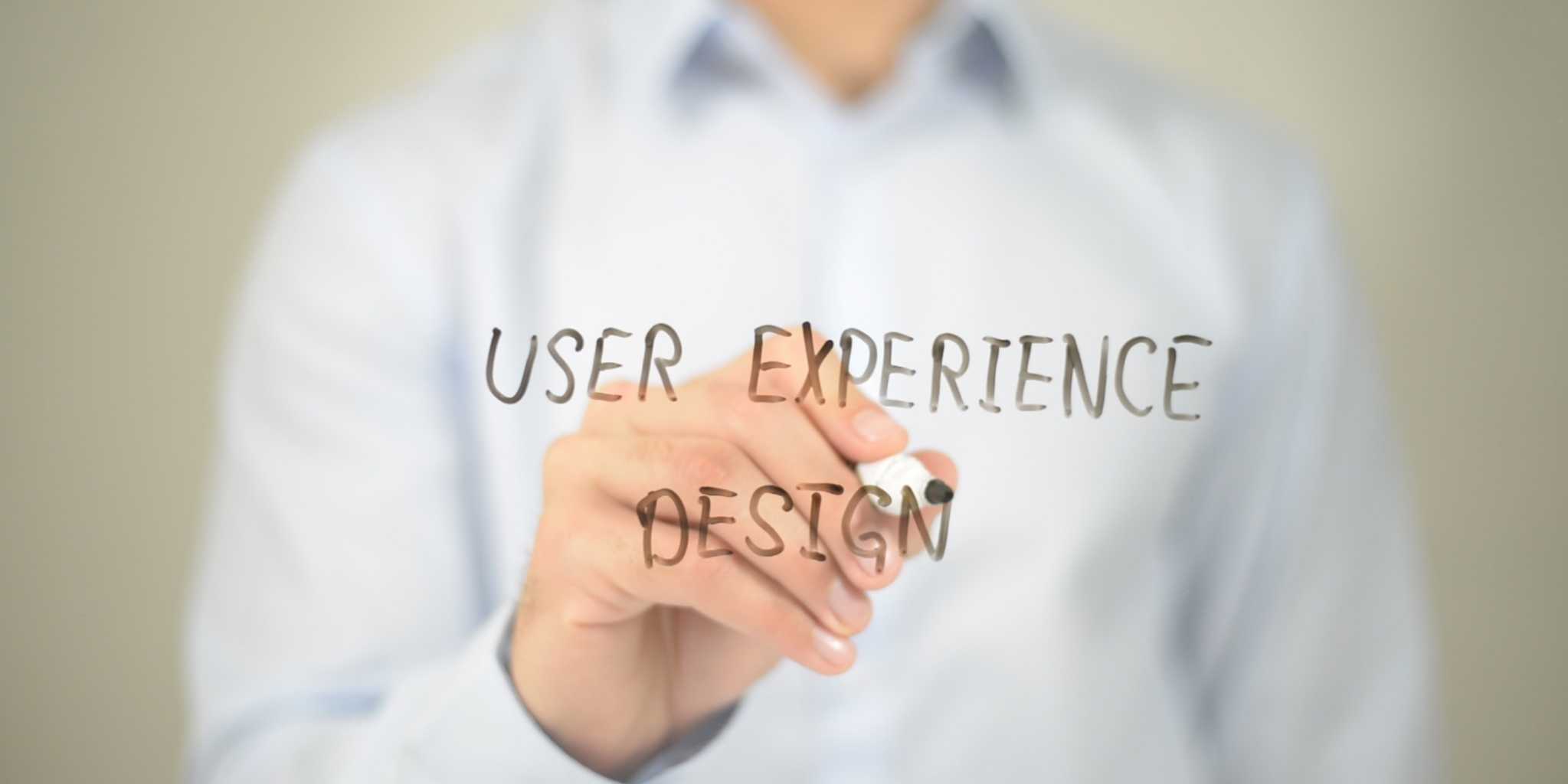 "USER EXPERIENCE DESIGN" written on glass with a dry erase marker.